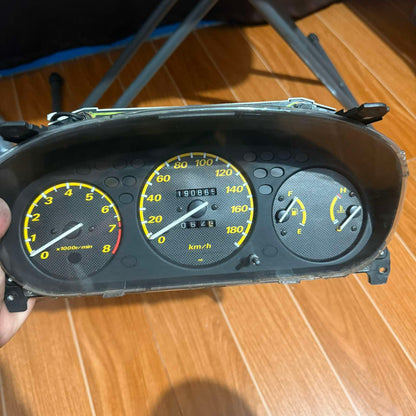Car dashboard instrument cluster on a wooden surface
